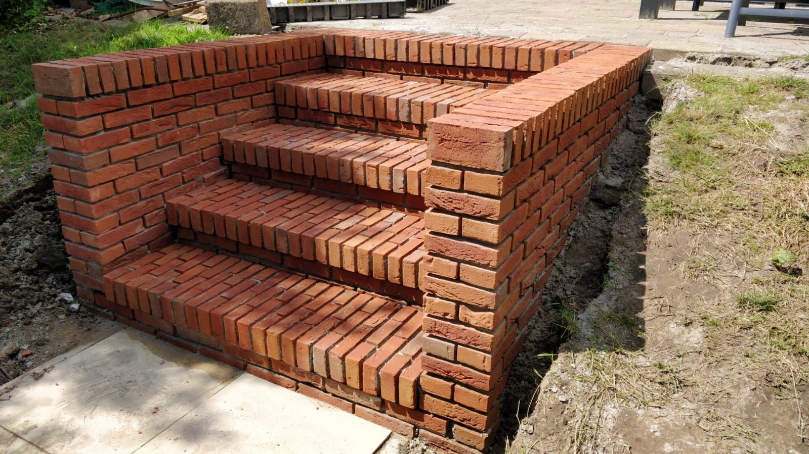 Nieuwe tuintrap van rode bakstenen met gemetselde zijmuren